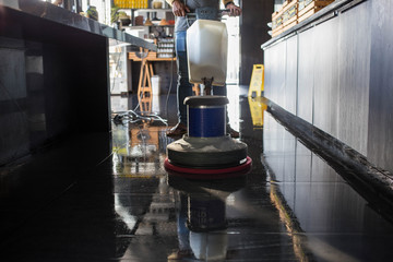 The people cleaning floor with machine.