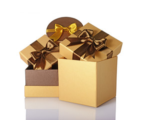 Three golden classic shiny gift boxes with brown satin bows