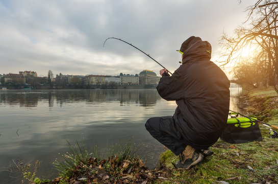 Sport fisherman trying to catch fish in river, urban fishing.
