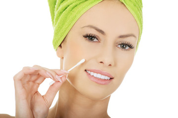 Woman removing make up with cotton bud.