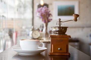Hot coffee placing together with coffee-mill by selective focus shoting