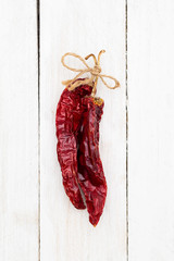 Dried red hot pepper on a white wooden background. vertical photo
