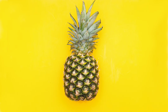 Fresh pineapple on a yellow background. View from above