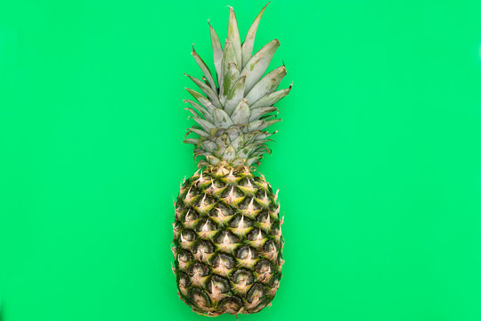 Tropical Pineapple fruit on a green background. Flat lay