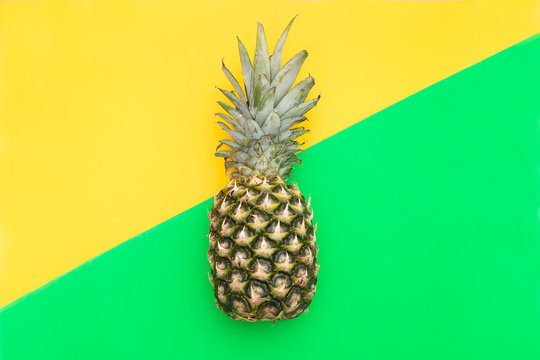 Tropical Pineapple fruit on a yellow-green background. Flat lay