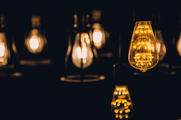 old retro vintage light bulb hanginh from ceiling with back background