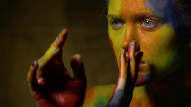 Sad mysterious woman in a multi-colored body art