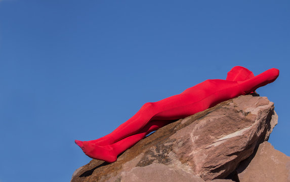 Mensch mit rotem Morphsuit auf Fels