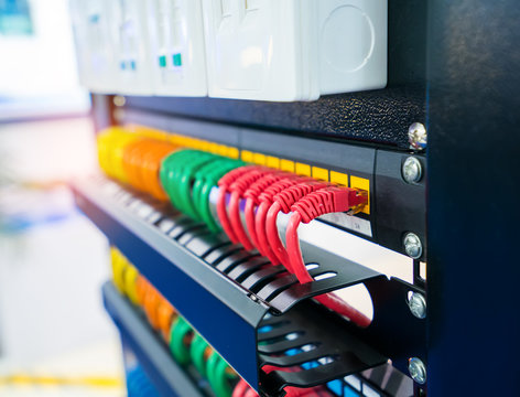 Server rack with internet patch cord cables connected to patch panel in server room