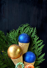 Christmas balls in waffle cones. Thuja branches in the background. Copy space