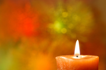 Obraz na płótnie Canvas Burning candle on a bright blurred background