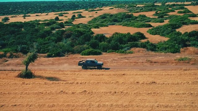 Aerial view pickup with armed bandits moving on rural road during pursuit