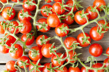 Cute cherry tomatoes on wooden background