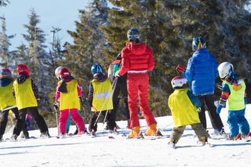 Poster Ski instructor teaching young kids to skiing © Geza Farkas