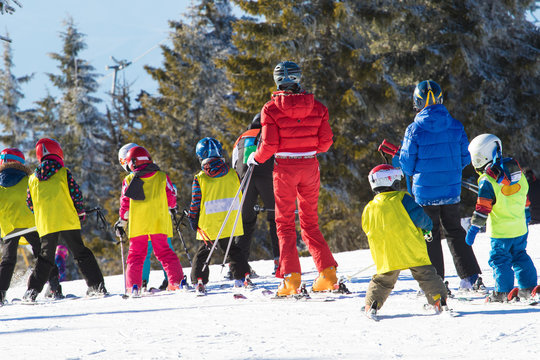 Ski instructor teaching young kids to skiing