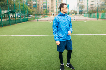 A young guy goes in for sports, portrait, handsome guy in sportswear. The guy works in the open, fresh air.