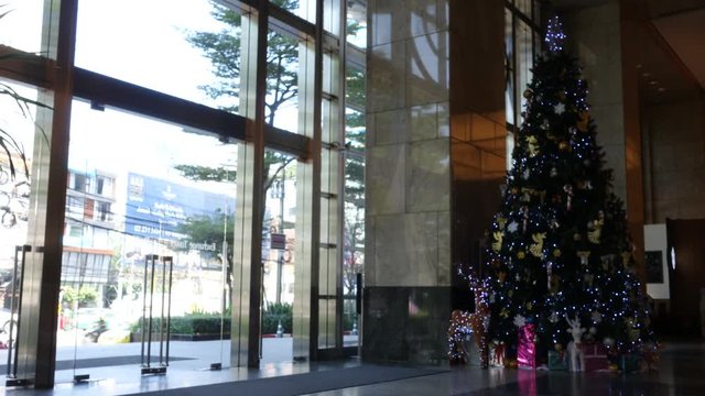 People walking at entrance, exit of office mall, decorate by Christmas tree. time lapse