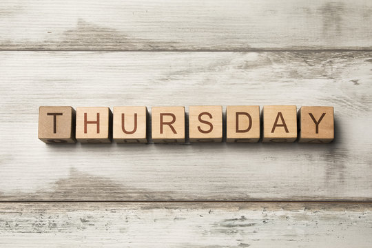 Thursday word written on wooden cubes on wooden background