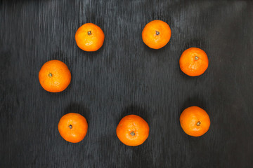 Tangerines on a black background. Lots of fresh fruit - mandarins.