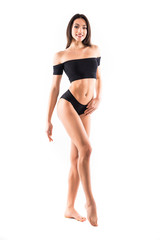 Fototapeta premium Young beautiful woman perfect body on white background in black sport clothes