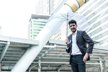 Business man holding umbrella at outdoors with building background. concept of insurance, security, protection and safety.