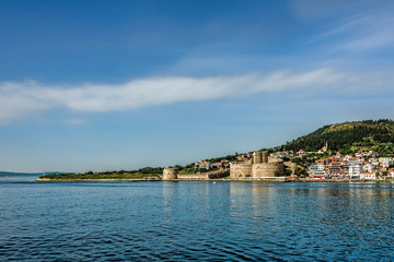 Fototapeta na wymiar Ancient castle on the seashore under clear blue skies with scatt