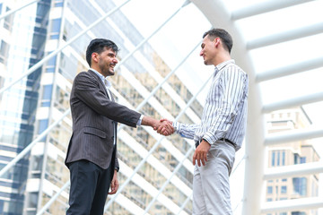 Two business man meeting partnership and shaking hands for deal success at site outdoors.