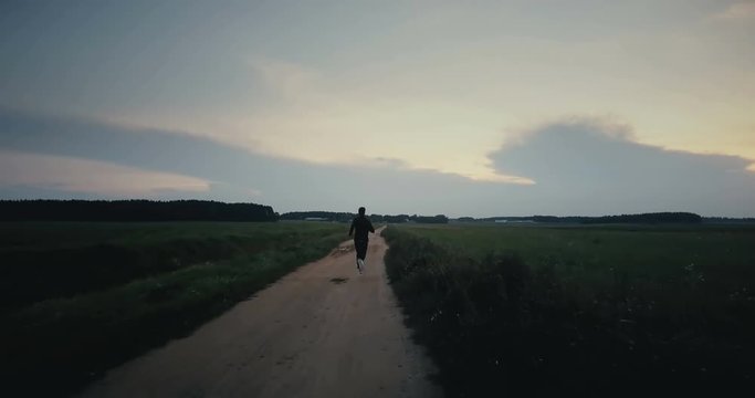 Sportsman running to amazing sunrise panorama. Young athlete back view. Best life moments. Cinematic ending shot.