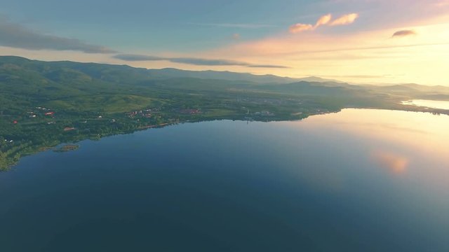 AERIAL: Panoramic view of several lakes in valley of mountains. Colorful sunrise landscape with hills and mountains on a background. Shot from great height.