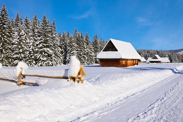 Winter road in Chocholowska valley with old wooden houses, Tatra Mountains, Poland