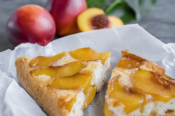 A pie with nectarines on a gray wooden table.