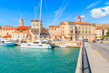 View of historic buildings and catamaran boat in Trogir town from bridge over canal, Dalmatia, Croatia - obrazy, fototapety, plakaty