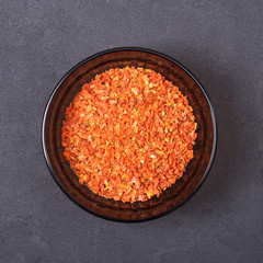 Dry carrot in a bowl on a grey concrete background