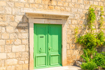 Fototapeta na wymiar Green door of old house in Splitska village, Brac island, Croatia
