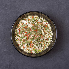Spice mix - celery, parsley, parsnip, leeks, onions, dill, basil, carrot in a bowl on a grey concrete background