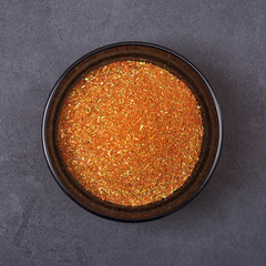 Spice mix - paprika, dried onion, white mustard, cumin, pepper in a bowl on a grey concrete background