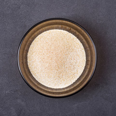 Garlic powder in a bowl on a grey concrete background