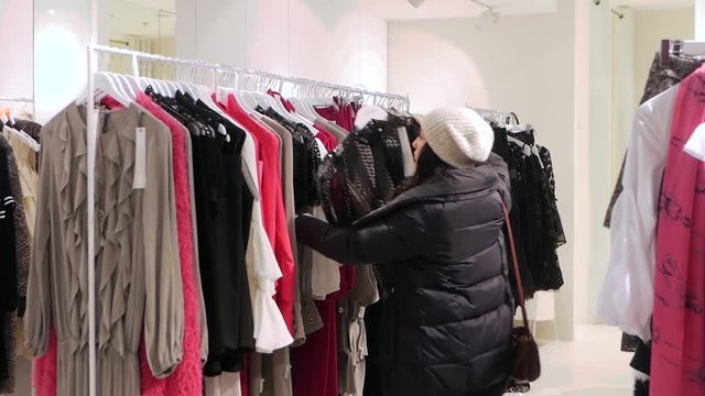Attractive young woman shopping for clothes fashion, browsing wardrobe