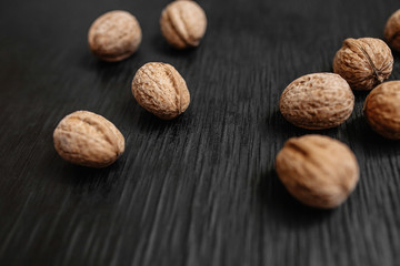 Lots of fresh nuts on a black wooden background. Best practices for designer