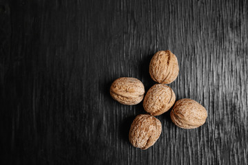 Lots of fresh nuts on a black wooden background. Best practices for designer. A beautiful design from the nuts