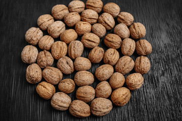 Lots of fresh nuts on a black wooden background. Best practices for designer. A beautiful design from the nuts
