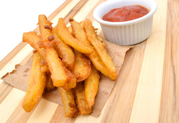 Homemade oil fried sweet potato fries on wooden board on white background