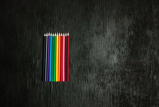 Many Colored Pencils On A Black Background. New Pencils