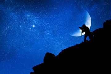 The photographer takes pictures of the stars in the mountains. Travel and space concept.