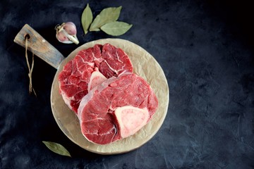 Fresh Organic Raw Beef Ossobuko on a bone on a wooden cutting board.