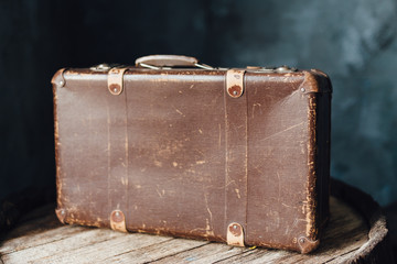 Old brown suitcase on the top of the barrel