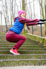 Sporty girl stretching outdoor in park.