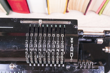 Old rusty retro calculator black standing on a wooden table