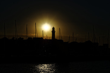 Sonnenuntergang im Hafen von Warnemünde an der Ostsee in Deutschland mit Leuchtturm und...