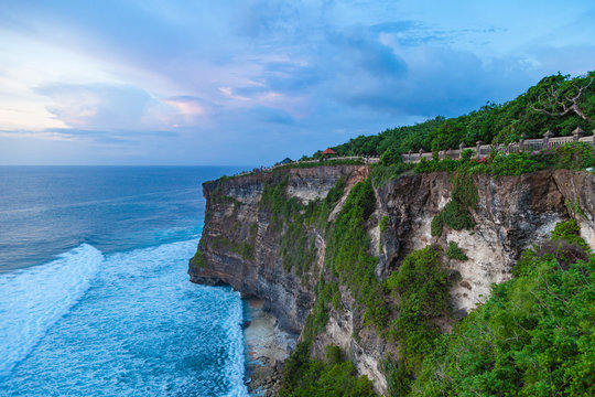Beautiful view of Uluwatu temple and ocean rocky cliff on sunset. Scenic landscape of fantastic view. Bali, Indonesia.